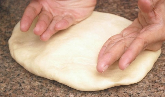 1. Этап. Улитки с корицей: 5. Тесто выложите на рабочую поверхность и раскатайте довольно тонко.