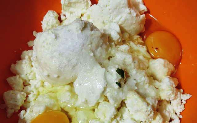 1. Этап. Пирог с зеленью: Творог разотрите с щепоткой соли и 2 яйцами.