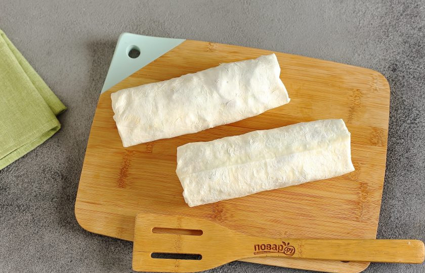 1. Этап. Фишролл: Поверх выложите нарезанный соломкой огурец, полейте все соусом, затем подверните края и сверните лаваш плотно в ролл. Таким же способом приготовьте второй фишролл.