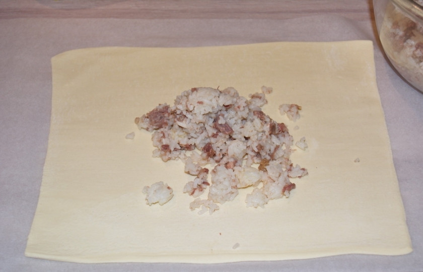 1. Этап. Пирог Походный: На тесто выложите начинку из риса и тушенки.