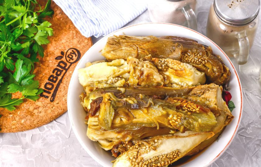 1. Этап. Баклажанная икра без уксуса: Затем срежьте хвостики у запеченных баклажанов, очистите их от кожуры, выкладывая мякоть в глубокую емкость.