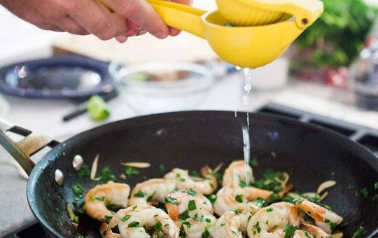 1. Этап. Креветки с чесноком и лаймом: 4. Добавьте сок лайма, перемешайте содержимое сковороды.