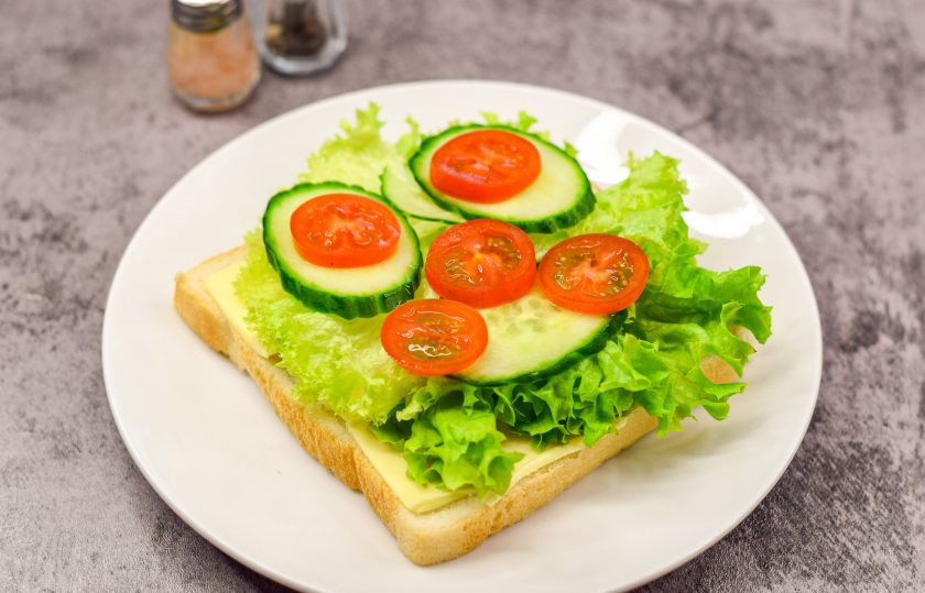 1. Этап. Бутерброд Тормозок: Поверх выложите салатные листья. Помидоры и огурцы нарежьте, выложите поверх салатных листьев.