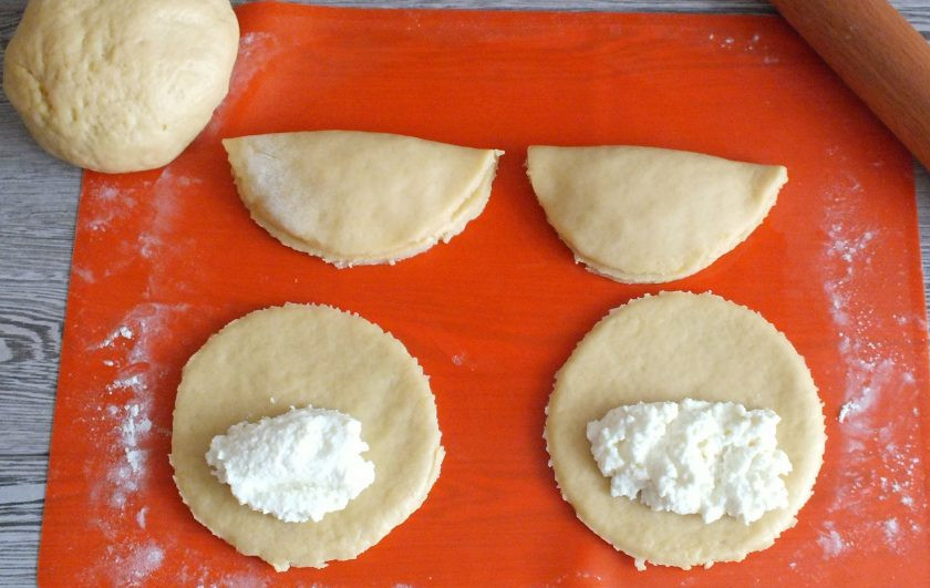 1. Этап. Сочни на маргарине: На каждый круг, ближе к центру, выложите по столовой ложке творожной начинки. Сверху прикройте половинкой теста и слегка прижмите ладонью.