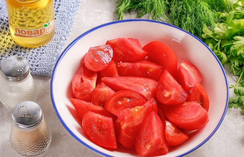 1. Этап. Пикантная закуска из помидоров: Помидоры промойте в воде, вырежьте из них зеленые сердцевинки. Вкуснее всего получится закуска из розовых помидоров. Нарежьте томаты крупными ломтиками в глубокую емкость.