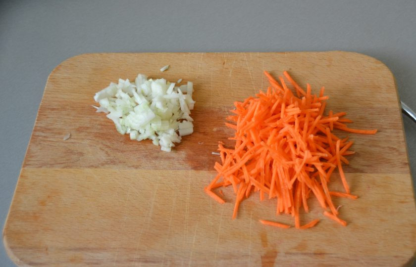 1. Этап. Куриный суп с сырными шариками: Мелко порежьте лук, а морковь натрите на терке.