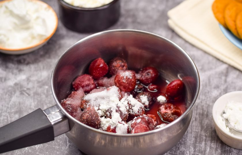 1. Этап. Вишневый десерт: В сотейник переложите вишню, добавьте воду, две ложки сахара и крахмал. У меня был картофельный крахмал, но можно использовать и кукурузный. Перемешайте все и поставьте сотейник на плиту, на небольшой огонь. Доведите до кипения и варите 2-3 минуты, помешивая.