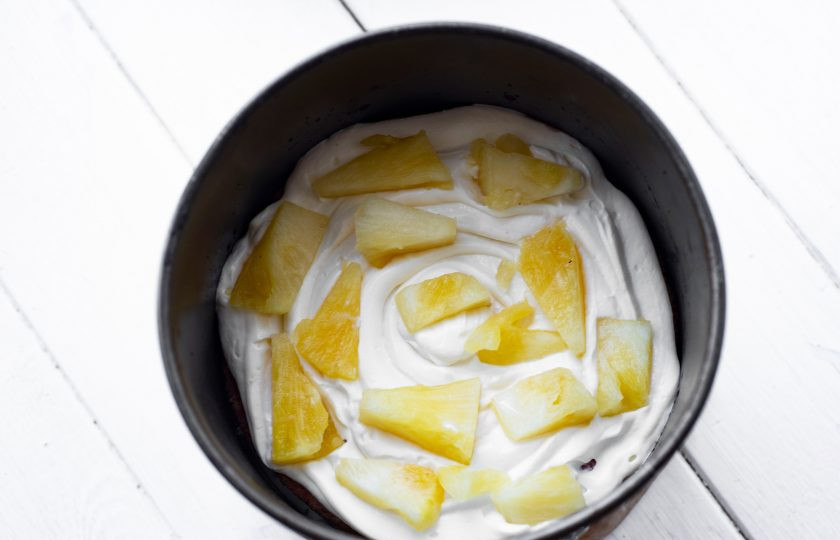 1. Этап. Торт с вишней и ананасом: Поверх выложите следующий бисквитный корж, пропитайте его сиропом, распределите по поверхности порцию крема, разложите кусочки ананаса в произвольном порядке.