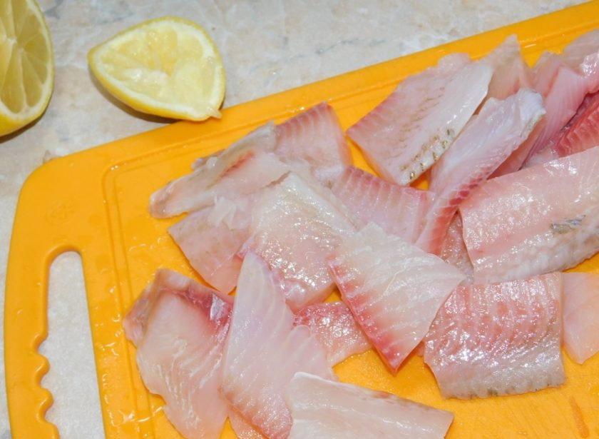 1. Этап. Тилапия в мультиварке: Рыбу нарежьте на кусочки и полейте лимонным соком.