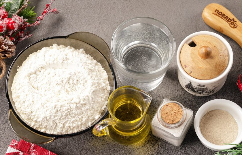 1. Этап. Новогодние пирожки Змейки: Подготовьте все ингредиенты для теста: муку, сахар, соль, растительное масло, дрожжи и тёплую воду. Муки может уйти от 2 до 2,5 стаканов.