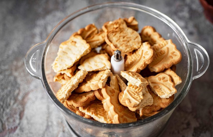 1. Этап. Колбаска Mинутка из печенья: Печенье поломайте кусочками и выложите в чашу измельчителя.