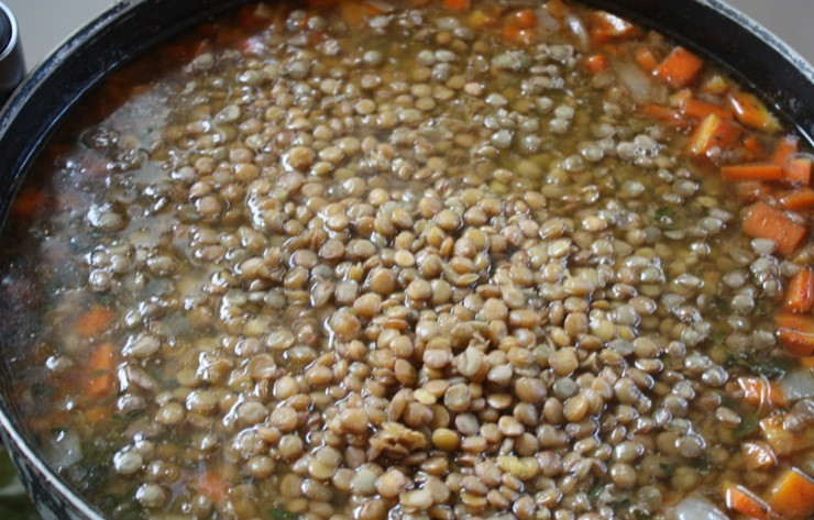 1. Этап. Суп из чечевицы с копченостями: 4. По истечению полутора часа выберите любисток, если хотите, можете снять мясо с косточки и вернуть в суп. Теперь следует добавить чечевицу с водой, в которой ее замочили и варить 30 минут. Или можно всыпать сухую чечевицу, влить дополнительный лист воды и варить 45 минут.