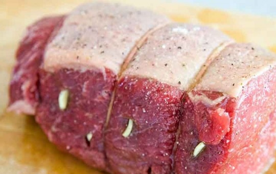 1. Этап. Вкусный рецепт говядины: Промойте мясо и оставьте, чтобы оно приобрело комнатную температуру. Затем чеснок порежьте кусочками и нашпигуйте им мясо со всех сторон, делая небольшие надрезы. Свяжите плотно мясо бечевкой или кулинарной нитью в нескольких местах.