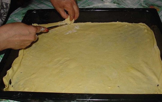 1. Этап. Армянская пахлава: 7. Теперь можно начинать собирать пахлаву. Один кусочек теста раскатайте тонко и выложите на противень, предварительно смазав его маслом или застелив пергаментом.