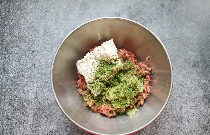 1. Этап. Котлеты из бобра: Всыпьте в фарш зелень, соль и поперчите.