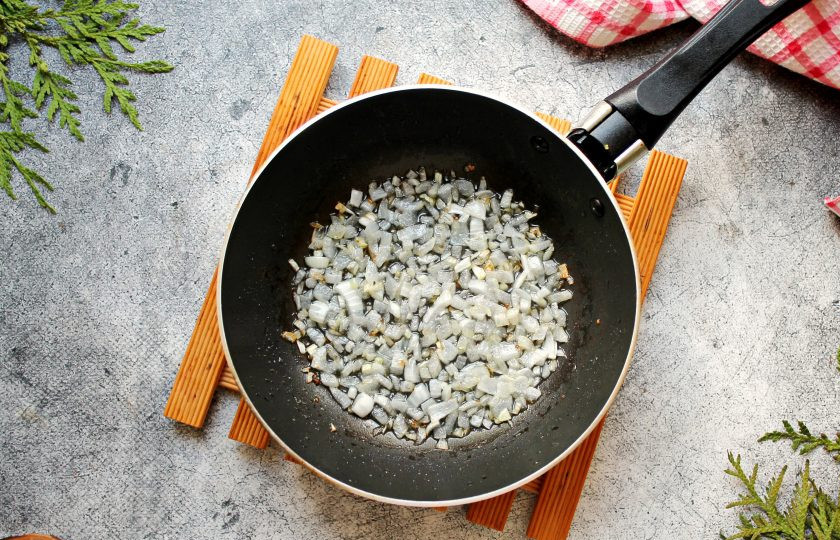 1. Этап. Запеченный картофель с беконом и сыром: В сковороду с жиром от бекона выложите мелко нарезанный репчатый лук и обжаривайте в течение 5-7 минут, до мягкости. Добавьте измельченный чеснок, перемешайте, жарьте еще 30 секунд и выложите в миску с картофелем и беконом, перемешайте.