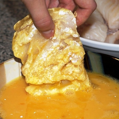 1. Этап. Жареное филе трески: В сковороду наливаем растительное масло, ставим ее на средний огонь. Пока сковорода разогревается, обмакиваем треску во взбитые яйца.