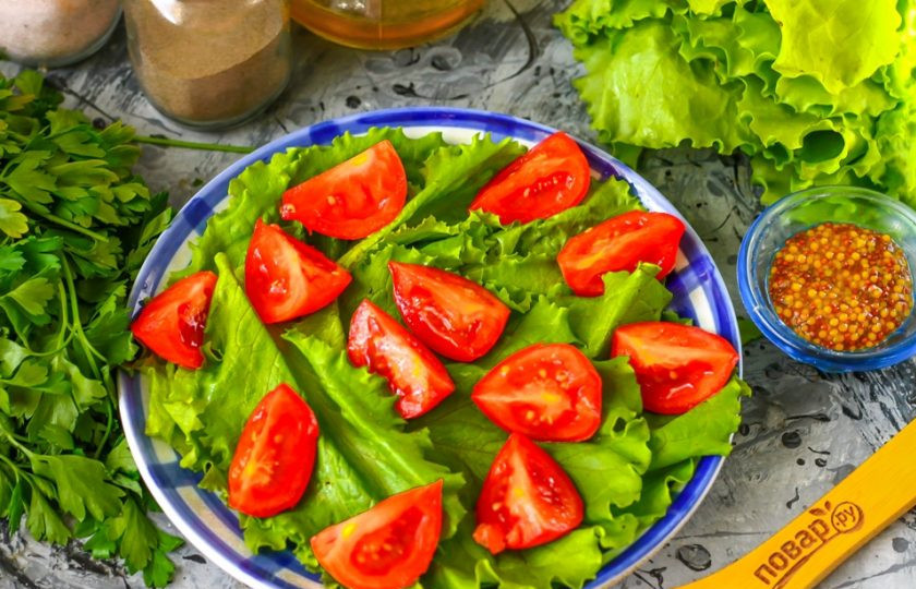 1. Этап. Легкий салат с креветками: Помидоры черри промойте в воде, вырежьте из них сердцевинки и нарежьте пополам или на четвертинки. Выложите на листья салата.