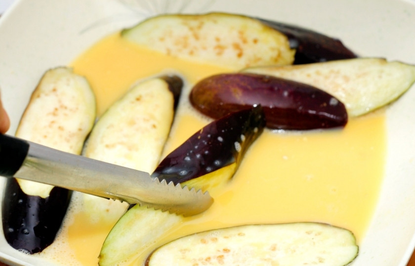 1. Этап. Баклажаны фри: Помойте баклажаны и нарежьте их одинаковыми по толщине ломтиками. Взбейте яйцо, посолите, и вымочите в яичной массе все ломтики баклажан.