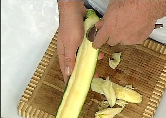 1. Этап. Кабачки с тушенкой: Разрезаем кабачок вдоль. Удаляем ложкой сердцевину.