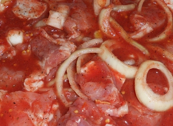 1. Этап. Шашлык в тандыре: Сложить в кастрюлю, пересыпав кольцами лука, и залить маринадом: томатный сок смешиваем с солью и пряностями. Больше в маринад ничего класть не нужно — хорошее мясо «само себя сделает». Тщательно перемешиваем и убираем в холодное место на несколько часов. Идеально — на ночь.