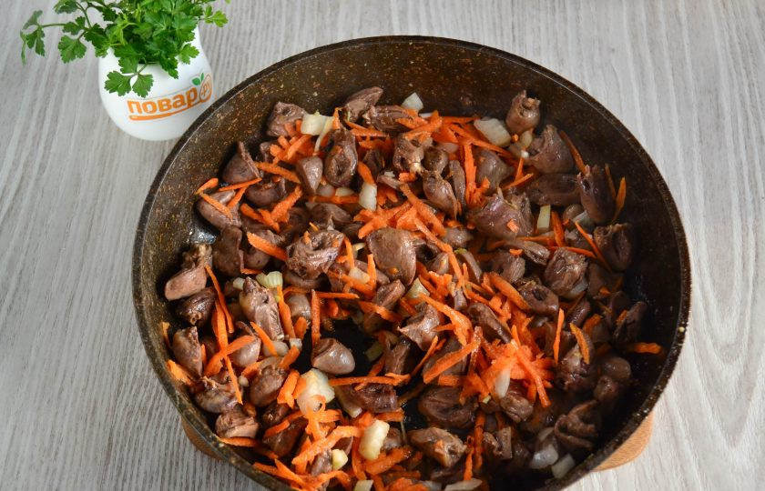 1. Этап. Куриные сердечки с макаронами: Когда жидкость из сердечек испарится, добавьте в сковороду морковь и лук, обжарьте в течение пары минут.
