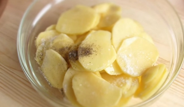 1. Этап. Картофель с мясом по-французски: 3. Картофель очистите и нарежьте тонкими пластинами. Добавьте оливковое масло, соль, перец.