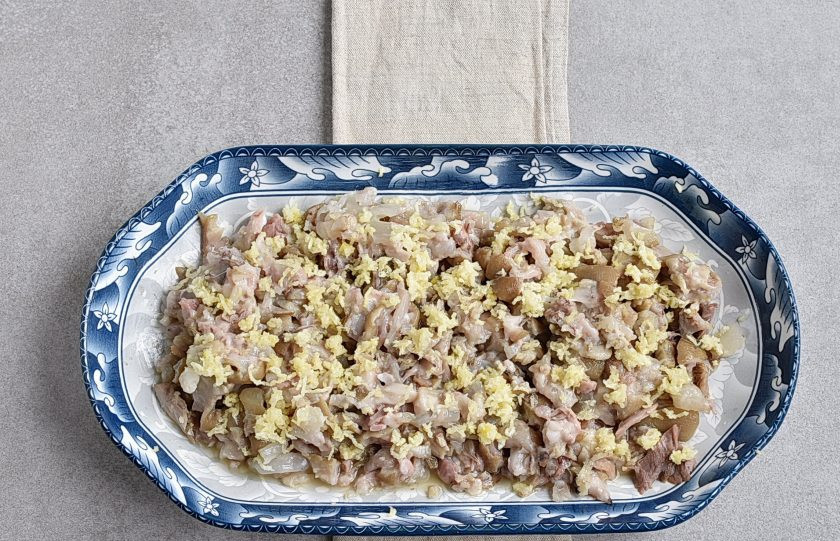 1. Этап. Холодец из свиных ножек в мультиварке: Разберите ножки, отделив мясо и кожу. Мелко порежьте. Выложите в судок или глубокое блюдо для холодца. Добавьте измельченный чеснок по вкусу и перемешайте.