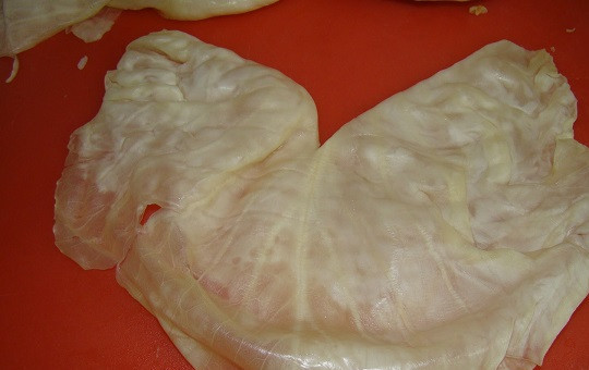 1. Этап. Голубцы в скороварке: 1. Для начала необходимо подготовить капусту. Сперва снять верхние листы, а затем опустить ее на 2-3 минуты в кипяток (можно отправить в микроволновку). Аккуратно достать и остудить. Снять листочек и разрезать его пополам, убирая жесткую перепонку, чтобы голубцы в скороварке в домашних условиях получились нежные.