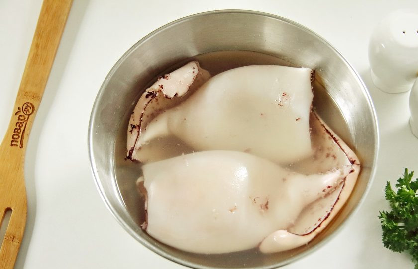 1. Этап. Фаршированные кальмары Мышки: Размороженные тушки кальмаров залейте кипятком на одну минуту, затем воду слейте, а кальмаров опустите сразу же в ледяную воду.