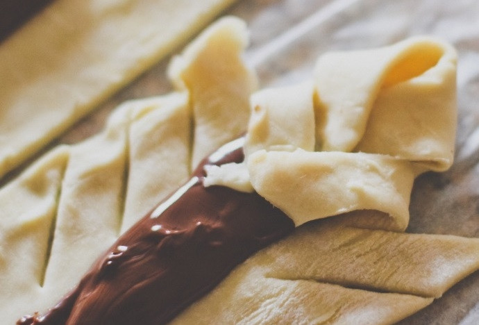 1. Этап. Слойки с шоколадно-ореховой пастой: 4. Внахлест уложите получившиеся края на шоколадную пасту, не слишком прижимайте.