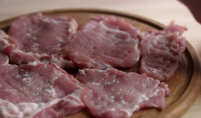 1. Этап. Картофель с мясом по-французски: 2. Накройте мясо пищевой пленкой и отбейте молотком с обеих сторон. Затем посолите и поперчите каждый кусок.