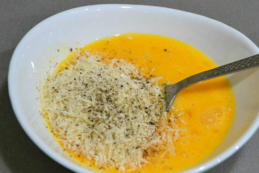 1. Этап. Карбонара без сливок: Всыпьте к яйцам 2/3 натертого на мелкой терке пармезана, поперчите, смешайте.