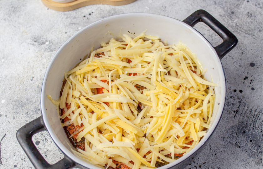 1. Этап. Тыква запеченная с травами и сыром: Натрите сыр и разложите поверх тыквы. Запекайте еще 5-7 минут.