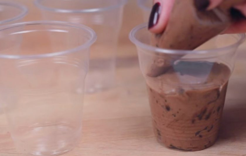 1. Этап. Шоколадный десерт на Хэллоуин: 3. Взбейте крем миксером. Добавьте взбитые сливки и смешайте с помощью лопатки. Переложите крем в кондитерский мешок и высадите его в стаканчики.