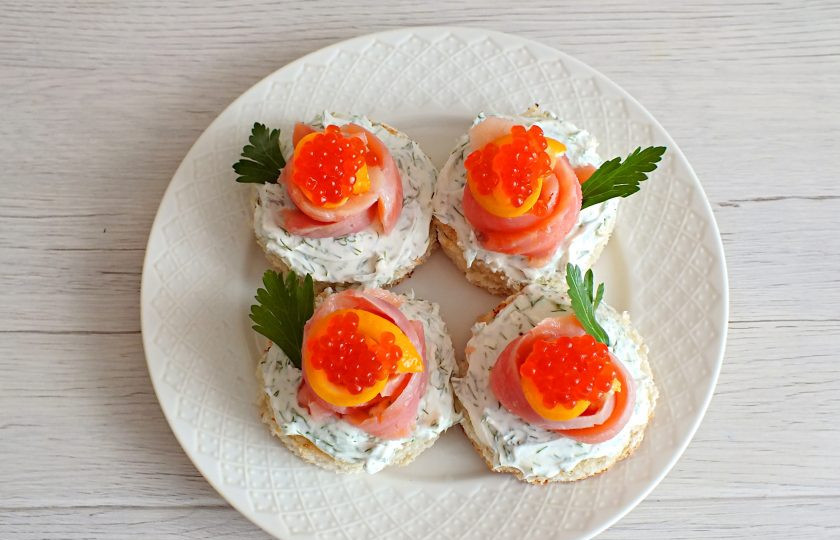 1. Этап. Бутерброды по-сахалински: В серединку лимона выложите по чайной ложечке красной икры. Закончите оформление листиками петушки.