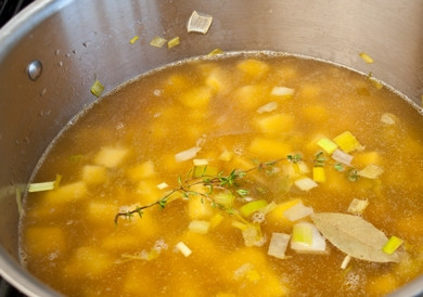 1. Этап. Суп с луком-порей: 4. Спустя 10 минут добавьте в кастрюлю картофель, лавровый лист, тимьян, залейте все содержимое бульоном.