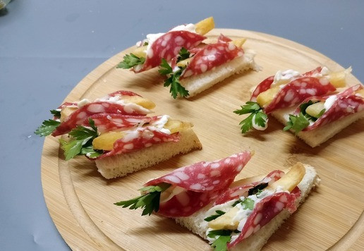 1. Этап. Мини-бутерброды Ассорти: Выложить подготовленную колбасу на хлеб.