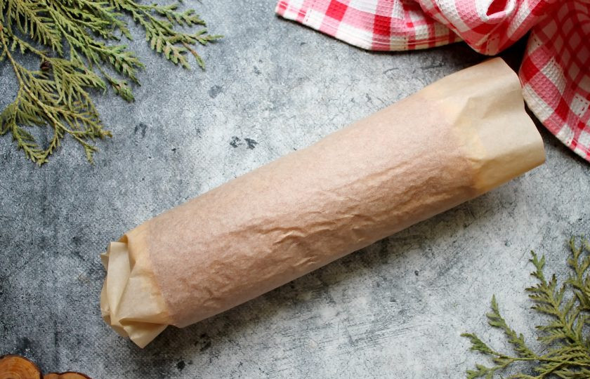 1. Этап. Рулет с крыжовником: Готовый бисквит переверните на чистый пергамент и заверните в рулет. Уберите в сторону и оставьте до полного остывания.