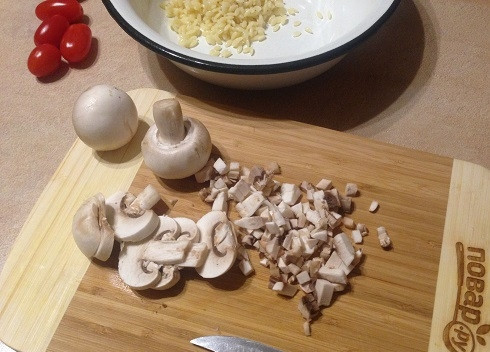 1. Этап. Перец, запеченный с пастой, грибами и сыром: 4. Вымоем и очистим грибы, а затем нарежем их мелкими кубиками. Отправляем в миску с пастой.