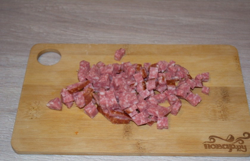 1. Этап. Салат с кукурузой консервированной: Салями нарезаем на кусочки (любого размера) и добавляем в салатник.