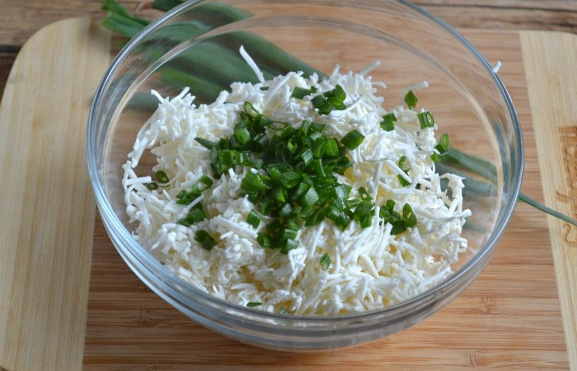 1. Этап. Закуска на чипсах: Мелко порубите зеленый лук и добавьте к сыру. Лук разнообразит вкус закуски, сделает ее более яркой.