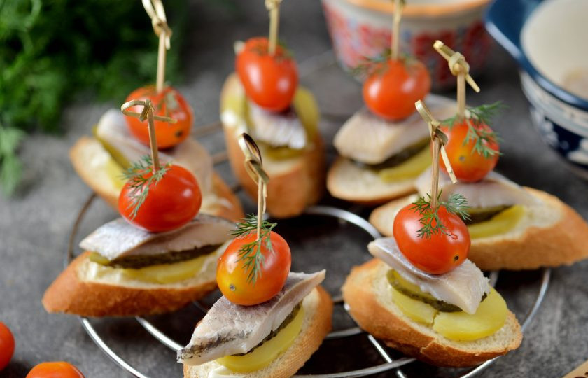 1. Этап. Канапе с селедкой и помидорами: На шпажку нанизайте помидор черри, скрепите ей всю конструкцию, украсьте листиком свежей зелени.