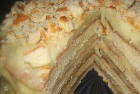 1. Этап. Торт на сковороде с творогом: Обрежьте готовые коржи по форме правильного круга, обрезки измельчите в крошку. Пееремажьте все коржи заварным кремом, затем обсыпьте крошкой из коржей торт со всех сторон. Поставьте на несколько часов торт в холодильник, чтобы он застыл.