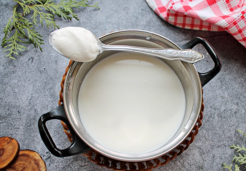 1. Этап. Вкусный домашний творог из молока и сметаны: Молоко налейте в кастрюлю с толстым дном и доведите до кипения. Затем снимите с огня и остудите до температуры 40 градусов. Выложите в молоко сметану и перемешайте до однородности. Накройте кастрюлю крышкой и поставьте в теплое место на 12 часов. За это время масса скиснет.