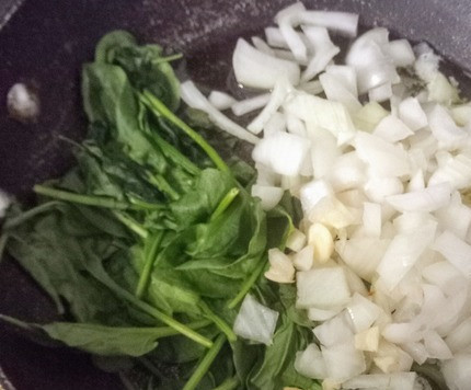 1. Этап. Яйца в шпинатовом креме с семенами: Отложить шпинат на одну сторону сковороды. На освободившемся месте разогреть масло, выложить лук, чеснок и немного соли по вкусу. Тушить 3 минуты.