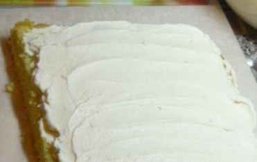 1. Этап. Торт Подарок: Разрезаем остывший бисквит на 3 коржа. Можно пропитать сиропом и выложить кусочки ягод или фруктов. Перемазываем коржи творожным кремом. А сверху и по бокам тщательно обмажем торт масляным кремом. Ставим в холодильник часа на 2.