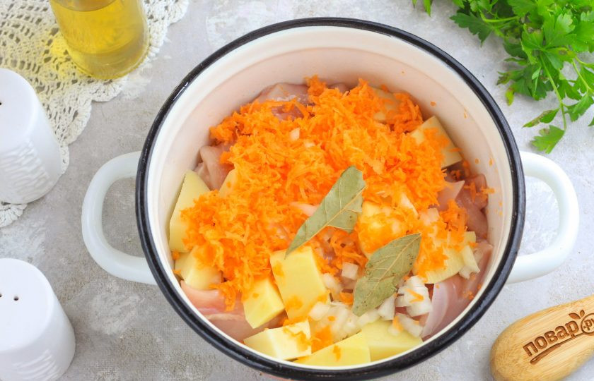 1. Этап. Суп из индейки с зеленым горошком: Натрите морковь на терке с мелкими ячейками, а лук нарежьте мелкими кубиками. Добавьте в емкость вместе с лавровыми листьями.