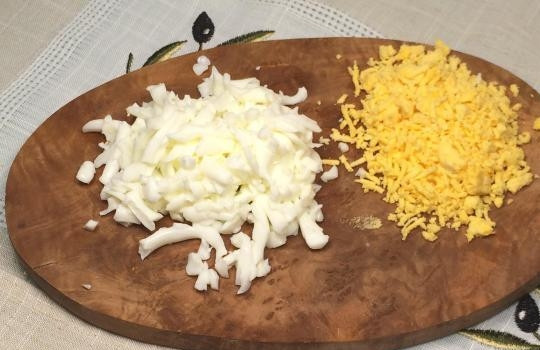 1. Этап. Салат Печень под шубой: Яйца отварите вкрутую. Белки натрите на крупной тёрке, а желтки — на мелкой.