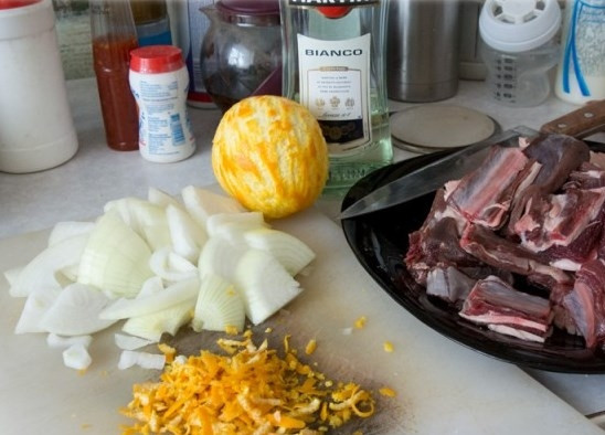 1. Этап. Оленина в горшочке: Вымойте апельсин и снимите с него цедру. Одну луковицу очистите от шелухи и нарежьте на кубики.